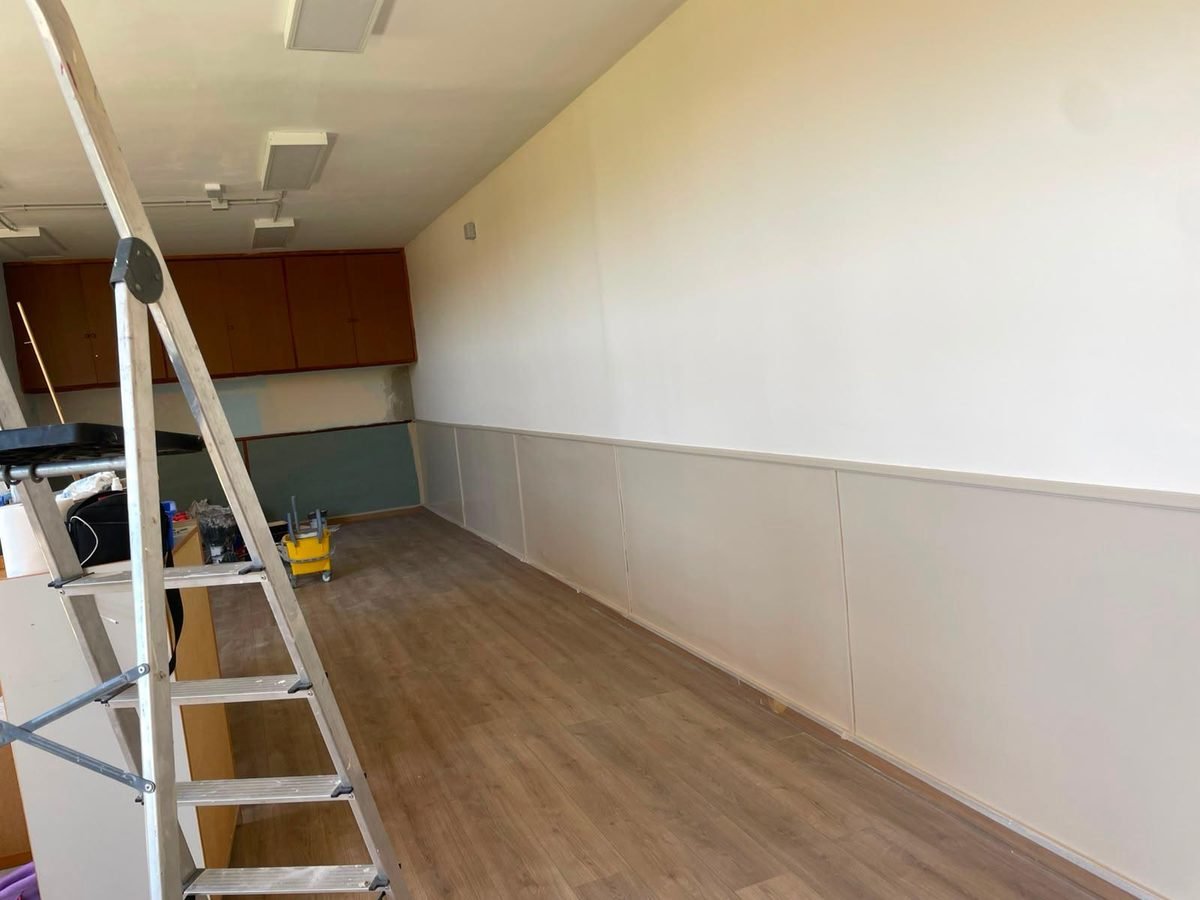 Local reformado con pintura clara, zócalo nuevo y suelo laminado por Pinturas y Reformas Abreu
